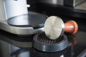 offee tamper and roasted coffee in rubber base photo