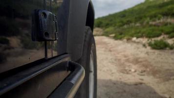 ein Kamera befestigt zu das Seite von ein aus Straße Fahrzeug Fahren auf Rau Spuren im Sardinien, Italien video