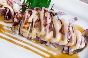 Grilled Squid with sauce on white plate photo