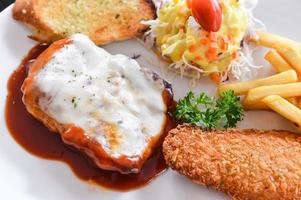 Chicken Steak and fried fish with salad and chips photo