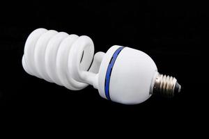 white energy saving bul or Illuminated light bulb on black background photo