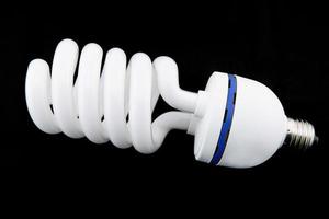 white energy saving bul or Illuminated light bulb on black background photo