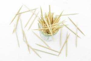 Toothpicks in transparent glass. Isolated on a white photo