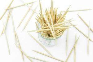 Toothpicks in transparent glass. Isolated on a white photo