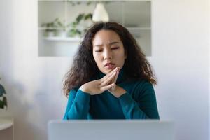 Asian Businesswoman Sitting at Her Desk Working on Laptop Computer in Big City Office. Confident Social Media Strategy Manager Plan Disruptive e-Commerce Campaign photo