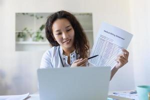 Asian female doctor having online therapy with her patient's, giving them advice while using telemedicine as a new normal during COVID-19 pandemic outbreak photo