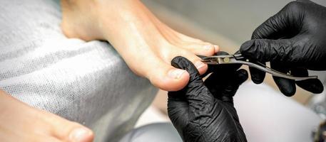 Pedicure master is cutting cuticle photo