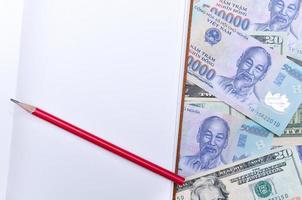 Vietnam y nosotros dólar divisa, cuaderno y lápiz foto