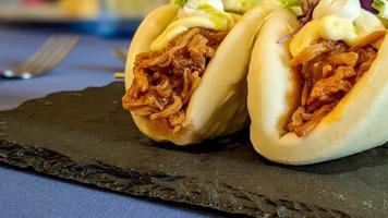 Fusion of asian and spanish food, bao bread with shredded meat. High quality 4k footage video