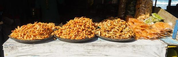 a woman's hand is picking and picking fried shrimp, to buy from a seafood merchant photo