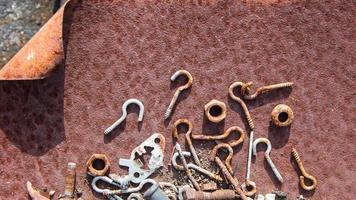Rusted screws, nuts and bolts in a rusty iron case, rusty nails, rusty chains, These rusty metal parts appear on the surface, rust background. photo