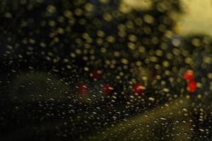 Night, drops on glass, red, yellow and blue lights from cars. Traffic jams. Bokeh background photo