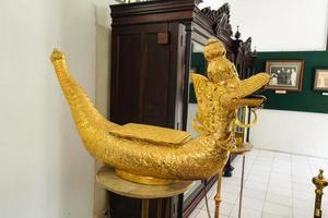 antiguo pavo real tallado estatua, hecho de oro mezclado latón, el patrimonio de el yogyakarta palacio foto