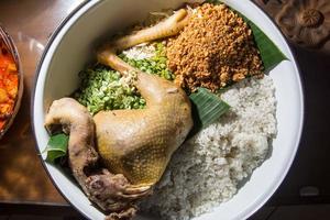 Boiled whole chicken Ingkung ayam is a Javanese Traditional dish, served in a large white bowl, which is Cooked for Celebration Rituals in Javanese Culture photo