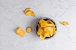 Sliced dried sweet potato in a bowl on the table. Homemade snack. Top view photo