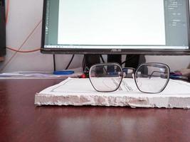 libro y gafas de protección con computadora monitor foto