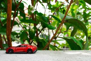 A photo of a red toy car, after some edits. Concept for nature adventure.