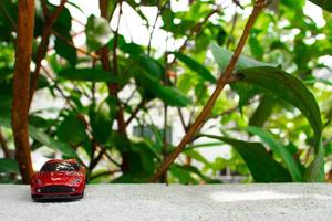 A photo of a red toy car, after some edits. Concept for nature adventure.