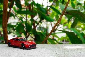 A photo of a red toy car, after some edits. Concept for nature adventure.