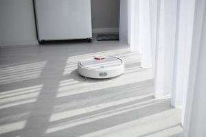 Robot vacuum cleaner cleans on a bright floor. photo