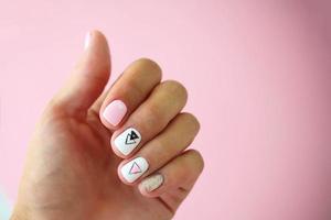 Female hands with a beautiful manicure on a pink background. photo