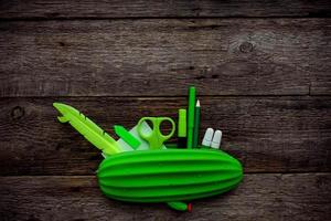 Pencil case and school supplies on a wood background. Stationery green. Back to school concept. photo