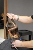 Male hairdresser splits long hair photo