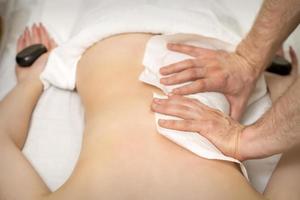 Masseur massaging back of woman photo
