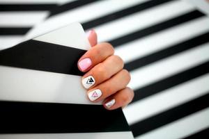 Female hands with a beautiful manicure on a striped background. photo