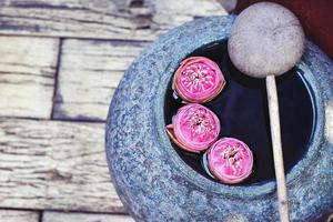 Beautiful lotus floating in a jar with water dipper photo