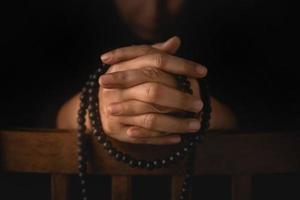 Spirituality, Religion and Hope Concept. Stressed Person Praying by Bead. Way to Practicing Mind and Mental Health. Supplication, Believe and Faith for Human. Dark Tone photo