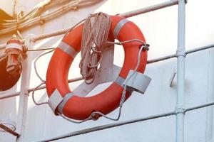 Lifebuoy on handrails of frigate or warship. Rope wound on handrails with lifesaver. photo