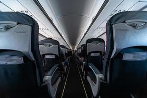 Airplane cabin seats with passengers. Economy class of new cheapest low-cost airlines without delay or cancellation of flight. Travel trip to another country. photo