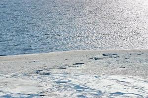 Melting sea ice seasonal natural phenomenon of coming spring, ice on water melts from burning sun photo