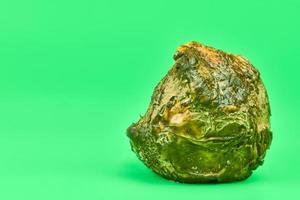 Rotten lemon, green background photo