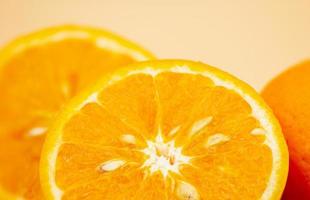 naranjas en rosado antecedentes. uno naranja es cortar en medio, el otro es entero. foto