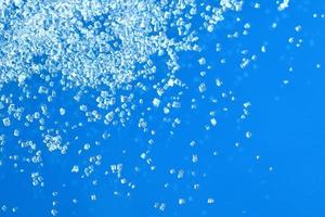 Top view of white crystal sugar isolated on blue background photo