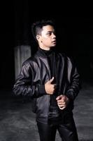 an Asian man wearing a leather jacket and black pants with a handsome face photo