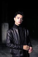 an Asian man wearing a leather jacket and black pants with a handsome face photo
