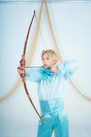 an Asian woman with blonde hair holding an arrow while wearing a blue dress photo