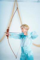 an Asian woman with blonde hair holding an arrow while wearing a blue dress photo