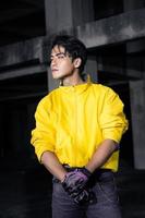 an asian man with a yellow jacket and black hair posing very gallantly photo