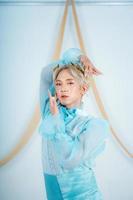 a princess with a blue dress and blonde hair posing very beautifully photo