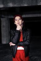 an asian man in a red shirt and black jacket posing with his hands photo