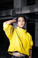 an asian man with a yellow jacket and black hair posing very gallantly photo