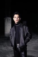 an Asian man wearing a leather jacket and black pants with a handsome face photo