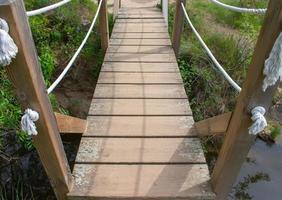 wooden pedestrian bridge and rope handrails photo
