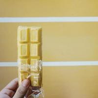 chocolate bar with ice cubes on a wooden background photo