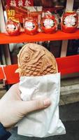 A fish ice cream sandwich in a hand photo