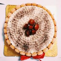 Tiramisu cake decorated with chocolate icing and fresh strawberries on top photo